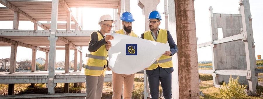 pracownicy na budowie czytają projekt